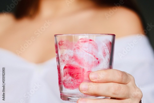 close up of a woman's hand holding a glass with traces of a kiss