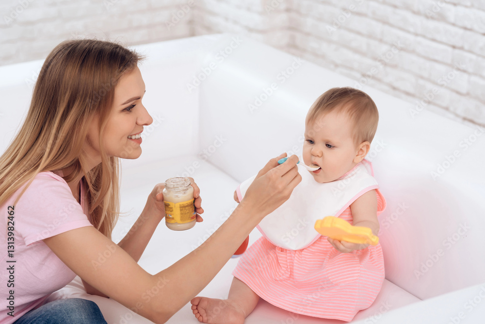 Smiling mother with puree feeding smiling baby. Smiling mother with puree feeding smiling baby.