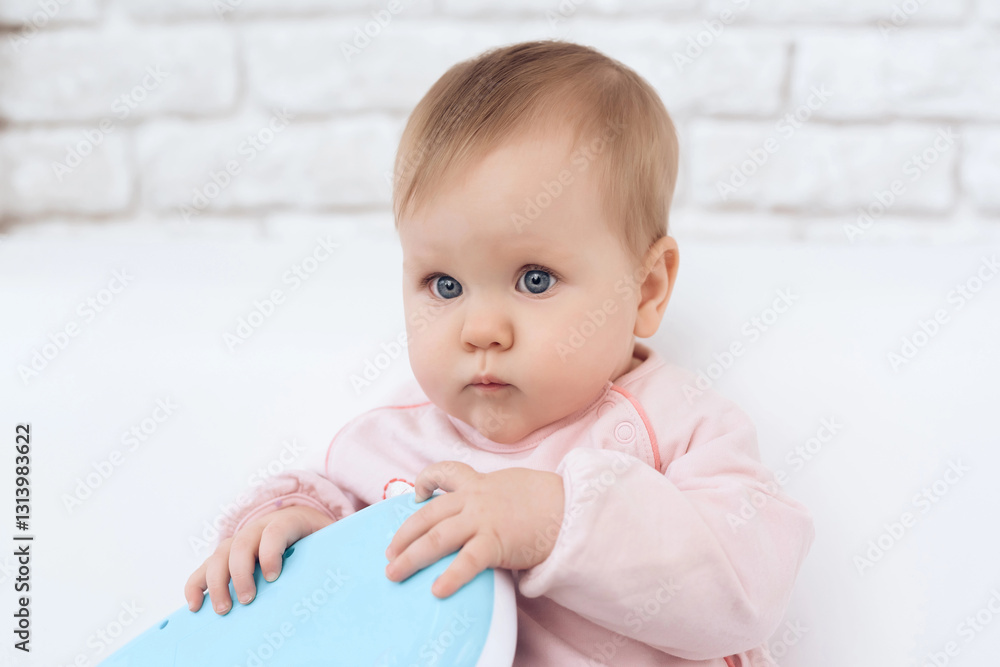 Fototapeta premium Portrait of smiling newborn baby playing toy.