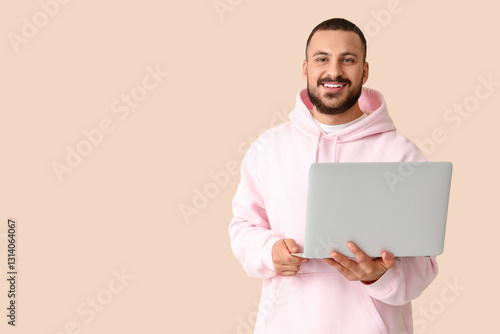 Smiling young man with lapt...
