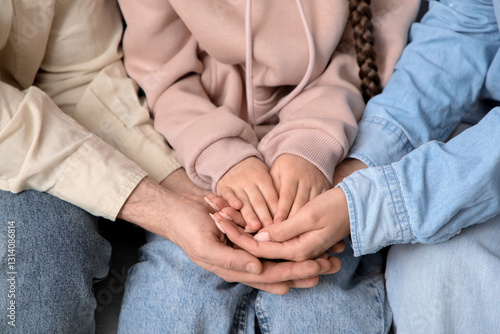 Tableau sur toile Couple with adopted girl holding hands, closeup