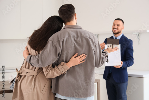 Young couple and realtor wi...
