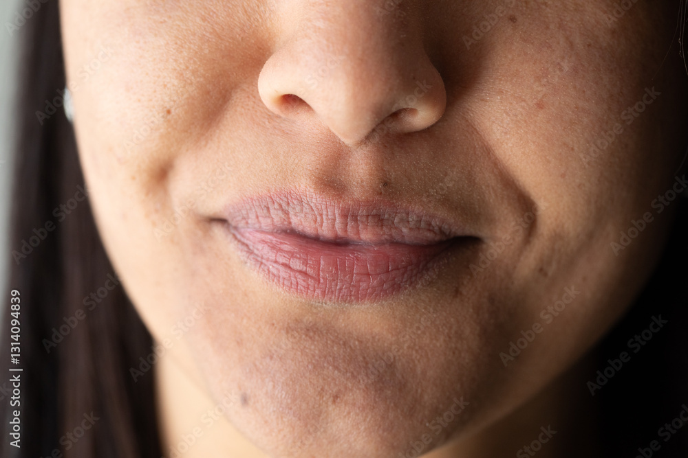 Woman showing slight smile and dimples on face Woman showing slight smile and dimples on face
