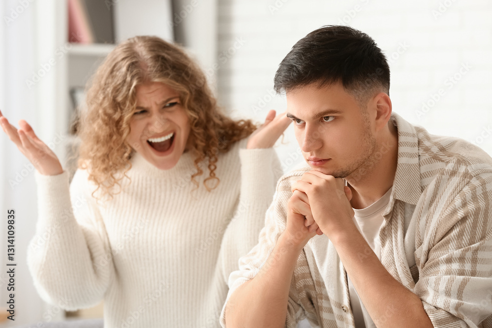 Screaming wife and thoughtful husband quarreling at home Screaming wife and thoughtful husband quarreling at home