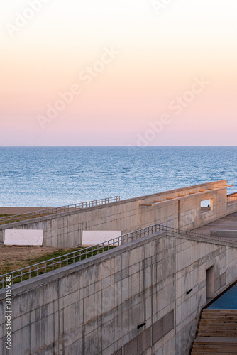 Concrete coastal structure with ocean view at sunset, Barcelona, Spain. photo