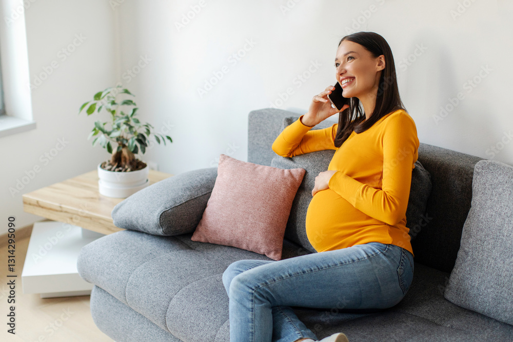Smiling pregnant lady talking on cellphone and caressing her belly, sitting on couch, expectant mother enjoying pleasant mobile conversation, free space Smiling pregnant lady talking on cellphone and caressing her belly, sitting on couch, expectant mother enjoying pleasant mobile conversation, free space