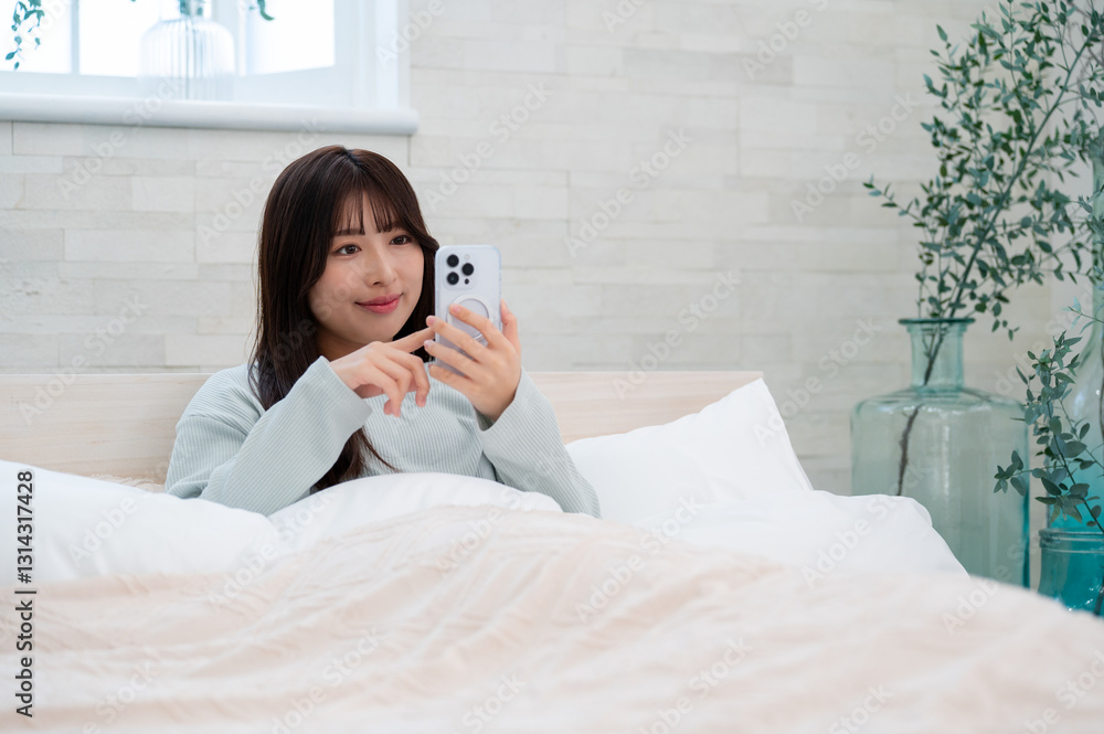 笑顔でスマホを見る日本人女性