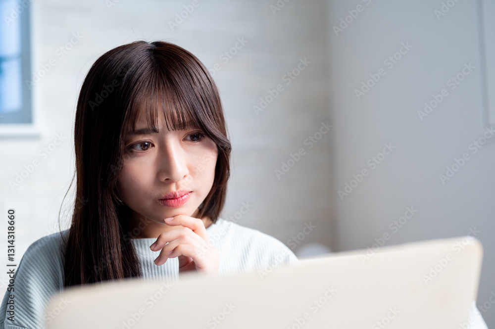 パソコンを見て悩む日本人女性