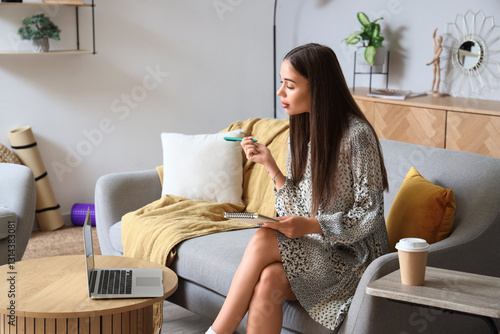 Young woman with laptop wri...
