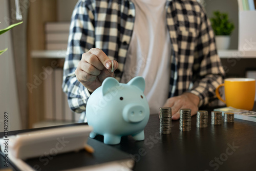 A man is managing the money he has saved in a piggy bank to pay his bills.
