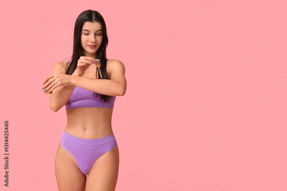 Obraz premium Beautiful young woman with bottle of cosmetic oil on pink background