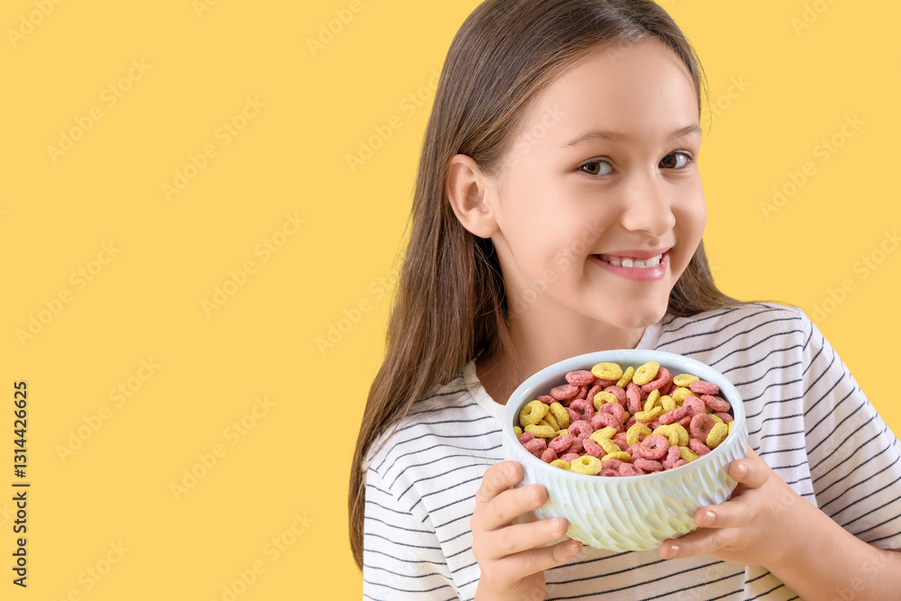 Cute little girl with bowl of cereal rings on yellow background Cute little girl with bowl of cereal rings on yellow background