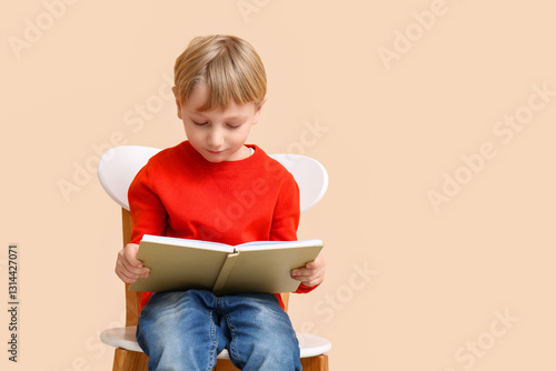 Little boy reading book whi...