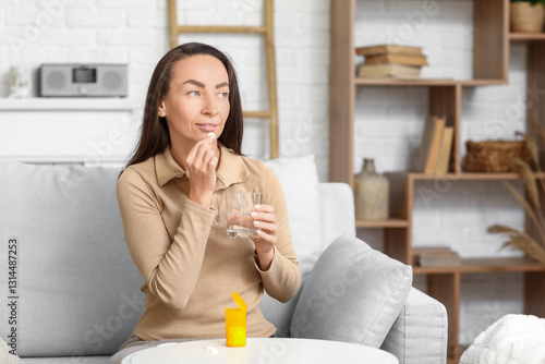 Woman taking medicine in room