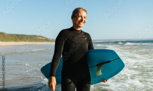 Obraz na plátně Senior woman enjoying surfing at the beach during a sunny day