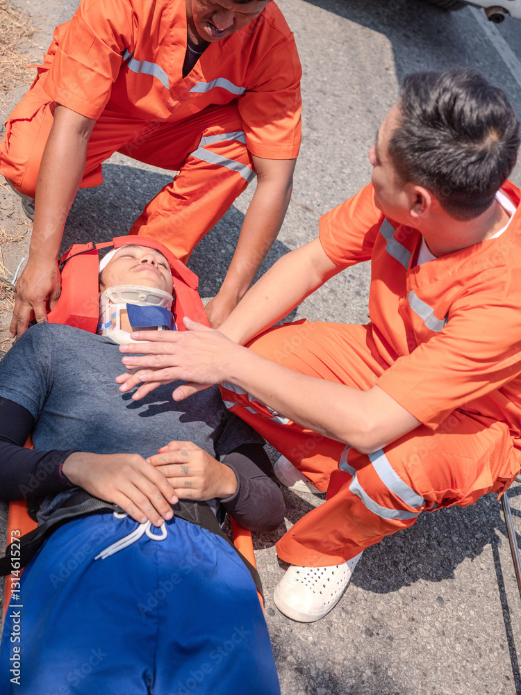 Two emergency medical personnel in orange uniforms providing first aid and assistance
