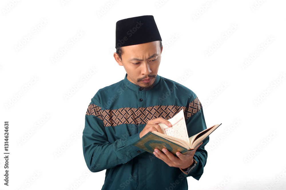 Asian Muslim man flipping through the Holy Quran and reciting during Ramadan, isolated on a white background Asian Muslim man flipping through the Holy Quran and reciting during Ramadan, isolated on a white background