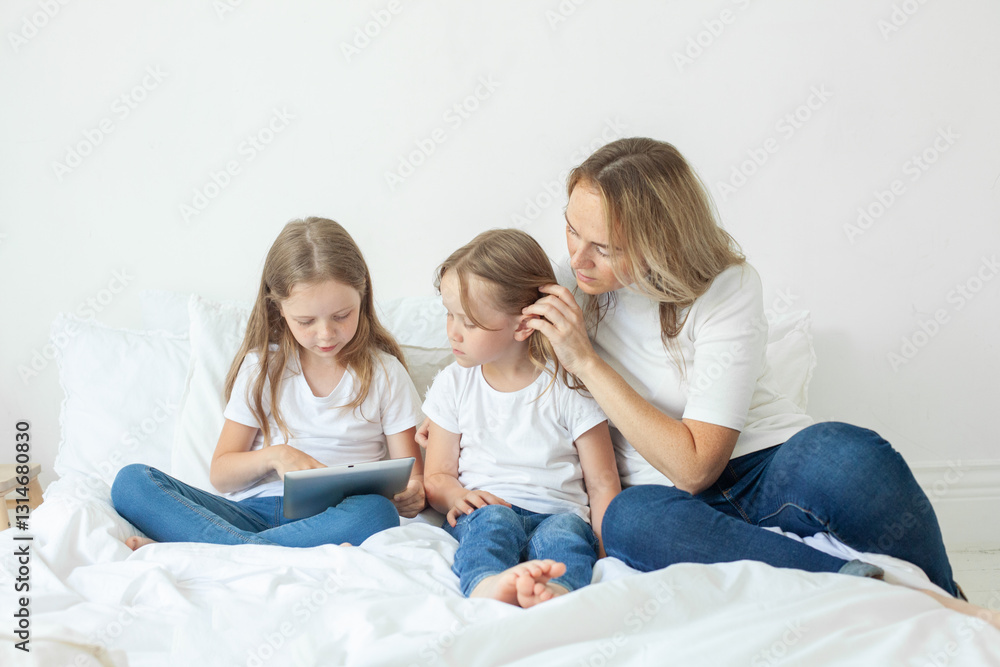 Happy family. Parents and their daughter having fun on a bed indoors Happy family. Parents and their daughter having fun on a bed indoors