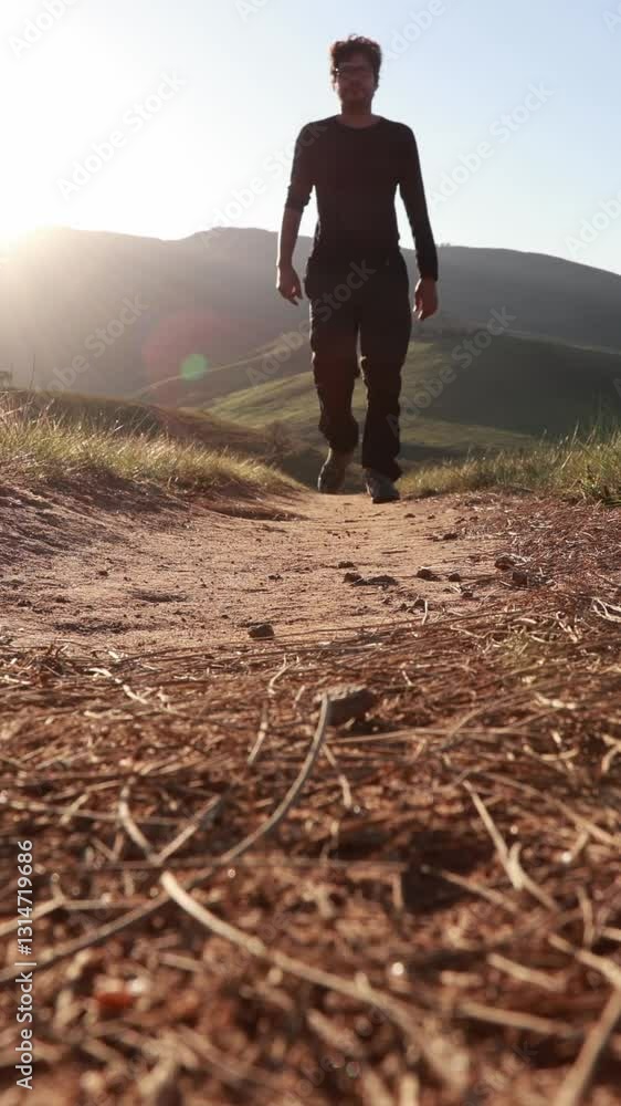 Homem andando pela trilha na natureza no pôr do sol Homem andando pela trilha na natureza no pôr do sol