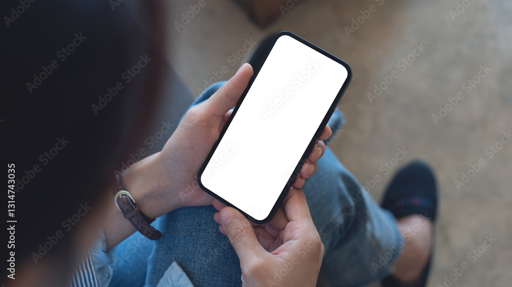 Cell phone white blank screen mockup, woman's hand holding mobile phone with blank screen and a cup of coffee in coffee shop, overhead shot, social media marketing design Cell phone white blank screen mockup, woman's hand holding mobile phone with blank screen and a cup of coffee in coffee shop, overhead shot, social media marketing design