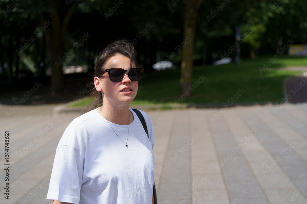 Fototapeta premium A woman in sunglasses and a white shirt. A close-up of an eye. A face with a tree in the background. A blurry black background.