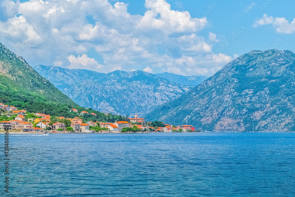 A panoramic view of the coastal village in Kotor Bay, Montenegro, surrounded by majestic mountains. The picturesque scenery captures the peaceful atmosphere of this Mediterranean town A panoramic view of the coastal village in Kotor Bay, Montenegro, surrounded by majestic mountains. The picturesque scenery captures the peaceful atmosphere of this Mediterranean town