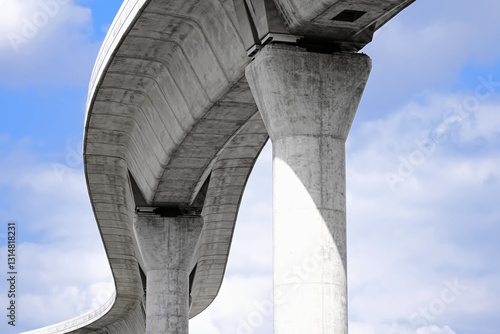 Low angle artistic photography of brutalist design concrete transportation infrastructure curve and pillars
