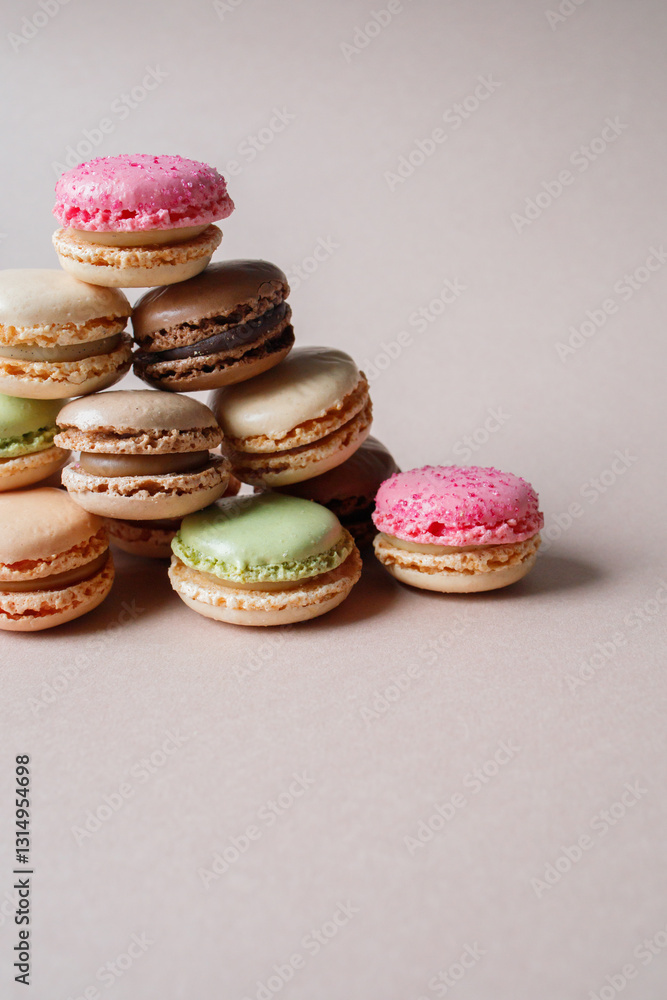 Fototapeta premium Pyramid made of multicolored macarons desserts on beige background