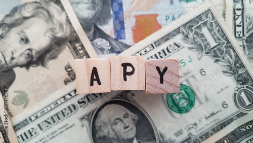 Wallpaper Mural APY acronym made of wooden letter cubes on pile of US dollar banknotes. Annual Percentage Yield Torontodigital.ca