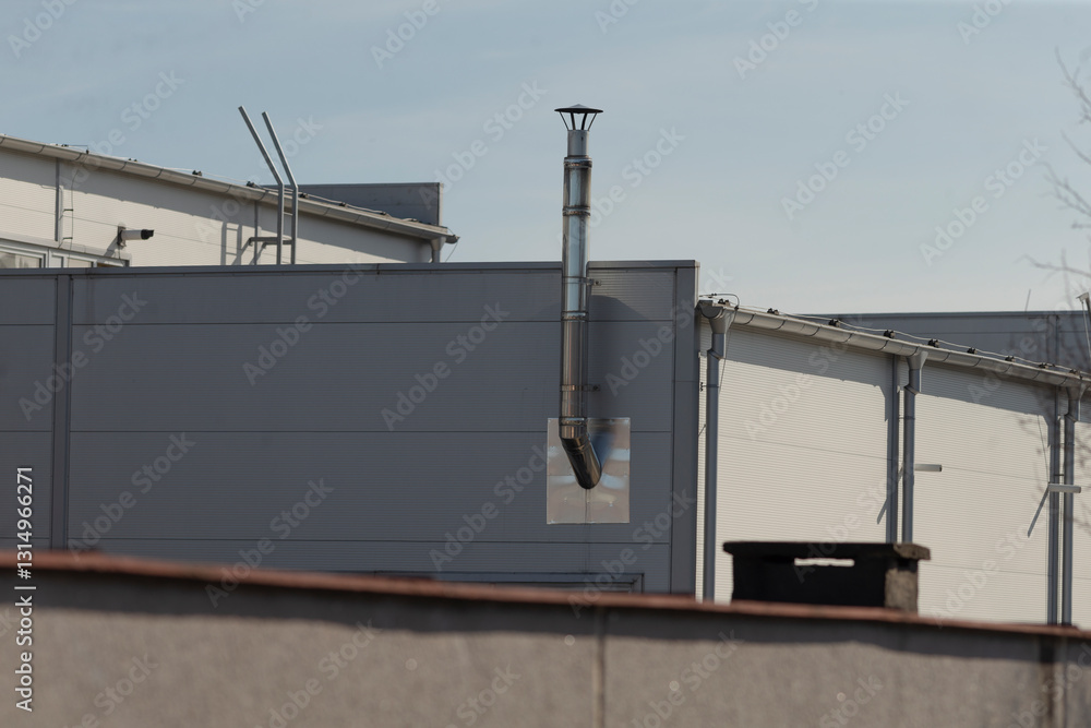 There is a building that features a prominent chimney located on one of its sides, adding character to its overall design and appearance There is a building that features a prominent chimney located on one of its sides, adding character to its overall design and appearance