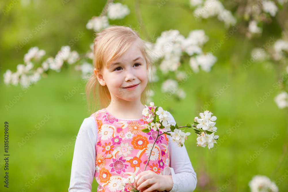 Little blonde girl admiring a blooming apple tree branch in a spring garden Little blonde girl admiring a blooming apple tree branch in a spring garden
