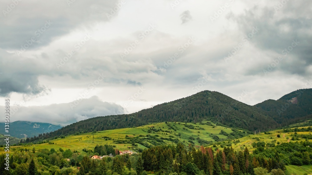 Fototapeta premium Dramatic clouds gather over the rolling green hills of the Carpathian Mountains on an overcast day.
