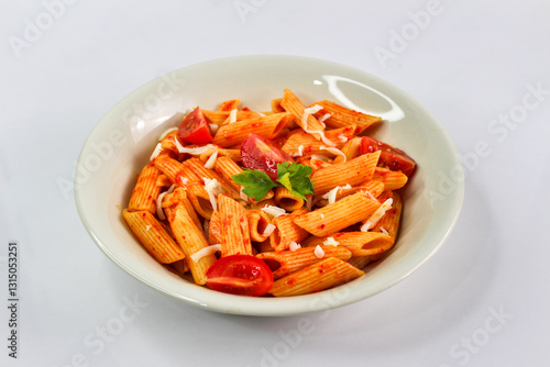 Classic italian pasta penne alla arrabiata with basil and freshly grated parmesan cheese on dark table. Penne pasta with chili sauce arrabbiata.