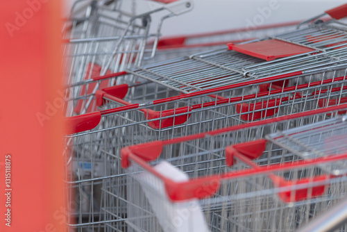 Bilde på lerret A multitude of shopping carts, all featuring bright red handles, are carefully s