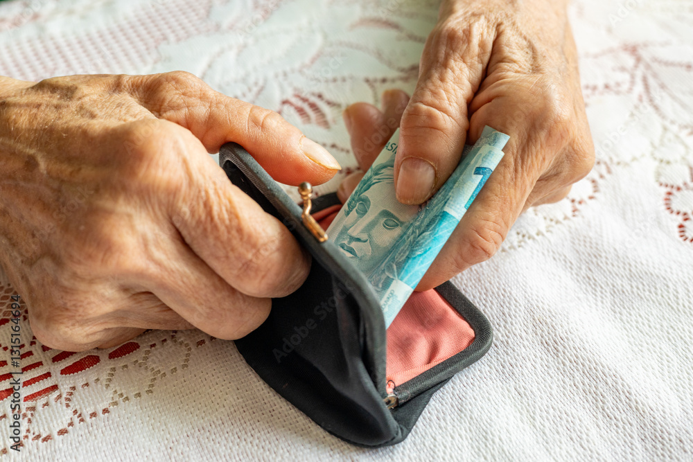 Brazil money. Senior woman's hands holding a roll of banknotes. Financial concept. Brazilian finances
