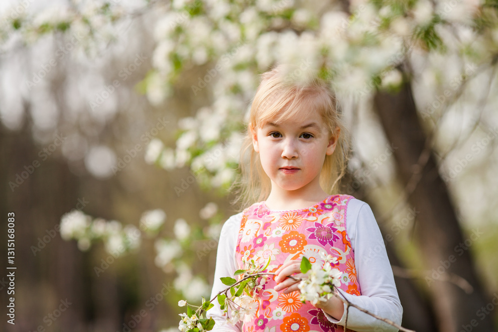 Little blonde girl admiring a blooming apple tree branch in a spring garden Little blonde girl admiring a blooming apple tree branch in a spring garden