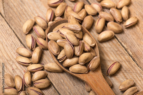 Pistachio nuts on a wooden trencher, natural and healthy snack concept	
 photo