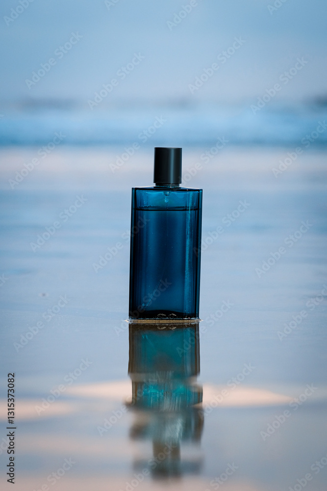 A sleek blue perfume bottle stands upright on a wet sandy beach, reflecting on the water's surface. The blurred ocean in the background creates a tranquil, luxurious aesthetic A sleek blue perfume bottle stands upright on a wet sandy beach, reflecting on the water's surface. The blurred ocean in the background creates a tranquil, luxurious aesthetic