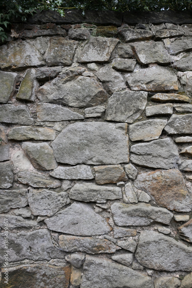 A wall made of stone with a few small holes in it A wall made of stone with a few small holes in it