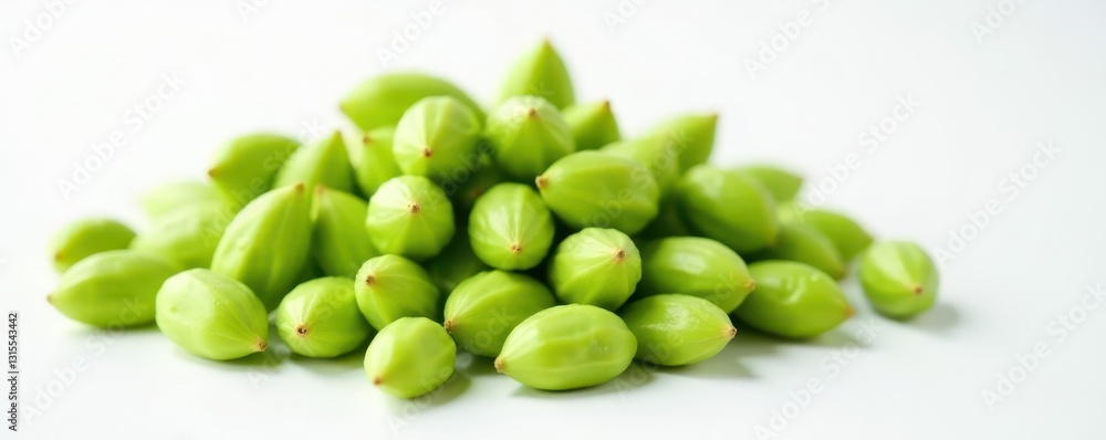 Pile of green cardamom seeds against a white surface, , seed, pod Pile of green cardamom seeds against a white surface, , seed, pod