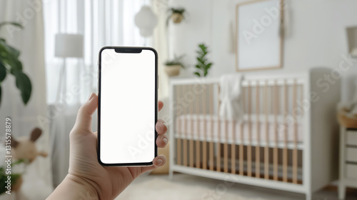 Woman holding smartphone in modern nursery with wooden crib and decorative elements, Mockup