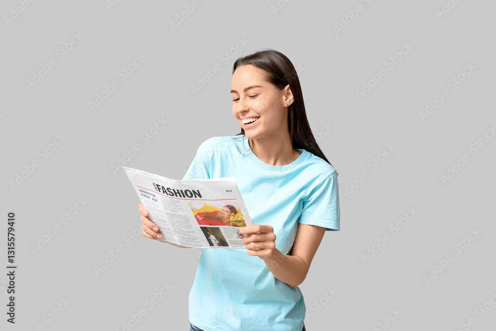 Beautiful young woman with newspaper on grey background Beautiful young woman with newspaper on grey background