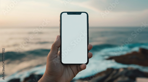 Blank smartphone display held by a caucasian adult against a scenic ocean backdrop, Mockup