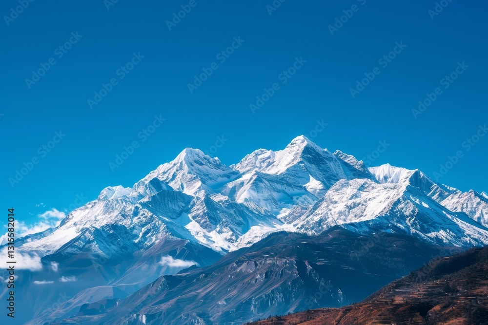 Fototapeta premium A panoramic view of snow-capped mountains against a vibrant blue sky, Snow-capped mountains under a clear blue sky