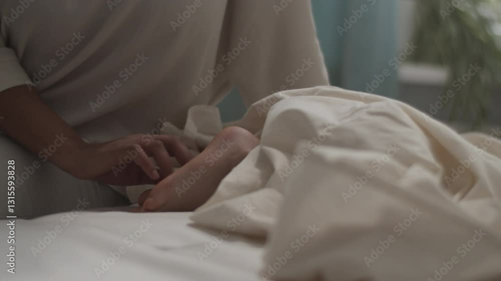 Unrecognizable mother waking up asleep daughter on bed Unrecognizable mother waking up asleep daughter on bed