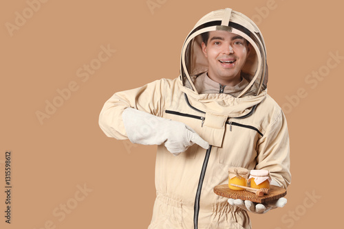 Male beekeeper pointing at ...