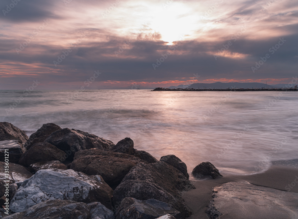 Calm ocean view at sunset with rocky shore and soft waves Calm ocean view at sunset with rocky shore and soft waves