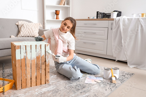 Young woman painting wooden...