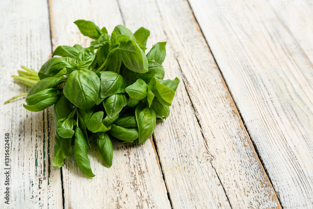 Fresh green basil leaves on white wooden background Fresh green basil leaves on white wooden background