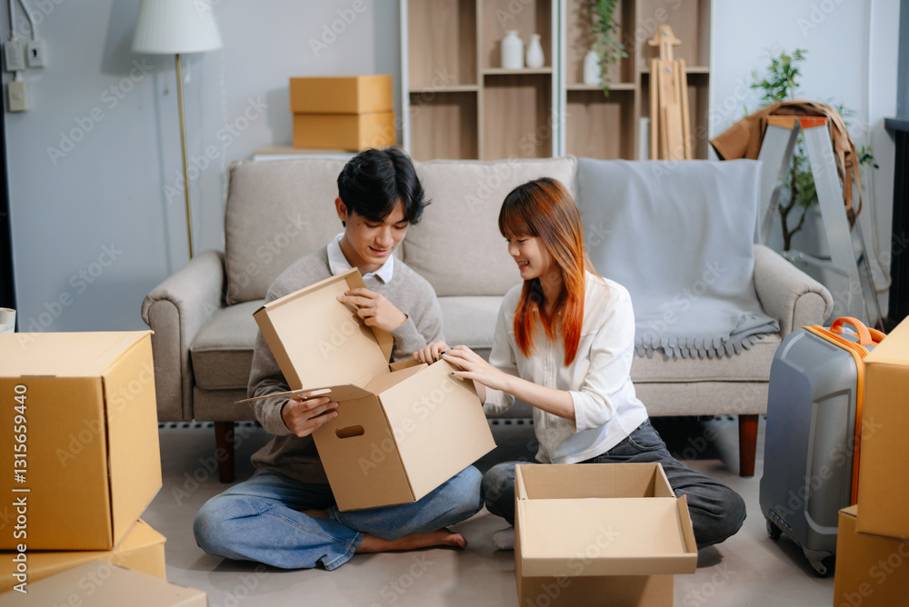 Young couple preparing for a move, packing boxes and a suitcase in a cozy living room. Perfect for themes of relocation Young couple preparing for a move, packing boxes and a suitcase in a cozy living room. Perfect for themes of relocation